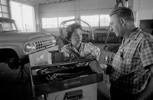 LKW-Fahrerin Mildred Cooper unterhält sich mit einem Mechaniker in einer Werkstatt von Ted Spiegel