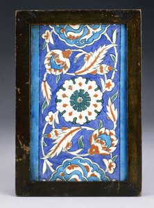 Eine Iznik-Randfliese mit einer zentralen Blütenknospe zwischen rollenden Palmetten und blättriger Ranke, ca. 1570 von Turkish School