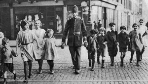 Polizist hilft Schulkindern über die Straße, East End, London, 1926-1927