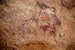 Felskunst, Vorgeschichte: Felsmalerei einer Gruppe von Rindern und polychromen Figuren (Hirten und Bogenschützen) in einem verzierten Schutzraum im Uweinat-Massiv, Sudan. Zeitraum von 8000 bis 3000 Jahre v. Chr. Fotografie von Unbekannt