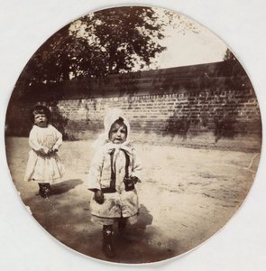 Zwei kleine Kinder gehen an einer Mauer entlang, um 1890