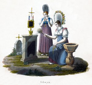 Zwei Frauen vor einem Grabstein auf einem Friedhof
