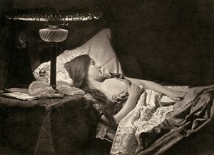Eine junge Frau schläft auf weißen bestickten Laken in einem Bett
