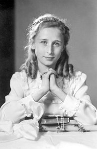 Christliches Mädchen mit gefalteten Händen in Gebetshaltung mit Bibel, Rosenkranz und Kerze (Foto der Kommunion). Fotografie um 1932