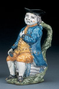 Toby-Krug mit blassem manganfarbenem Gesicht und Händen, hält einen leeren kugelförmigen bufffarbenen Krug in gewaschener blauer Jacke und Hose und grünem Wams, ca. 1800