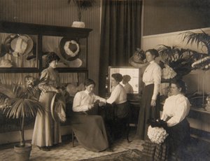 Fünf Damen in einem Hutgeschäft