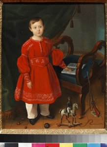 Porträt eines Jungen in einem roten Kleid mit Spielzeug und einem Alphabetbuch