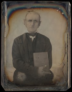 Porträt eines Mannes mit Koteletten, der ein Buch hält von Unknown artist