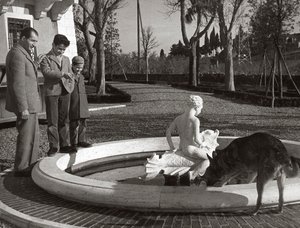 Gino Bartali mit zwei Kindern und einem Hund in der Nähe eines Brunnens von Unknown photographer
