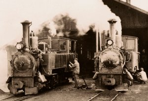 Zwei Dampflokomotiven werden von zwei Arbeitern gewartet von Unknown photographer