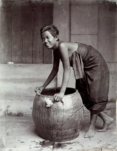Junge lächelnde thailändische Frau, die einen großen Behälter schiebt von Unknown photographer