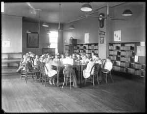 Kinder hören einer Frau im Lesesaal einer nicht identifizierten Filiale der Queens Borough Public Library zu, ca. 1910
