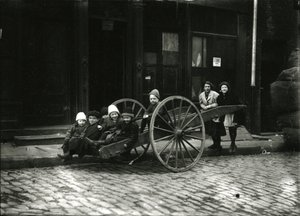 Gruppe von Kindern im Wagen, mit Mädchen und Frau dahinter, ca. 1910-21 von William Davis Hassler