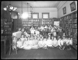 Gruppenporträt von Kindern im Lesesaal einer nicht identifizierten Filiale der Queens Borough Public Library, um 1910