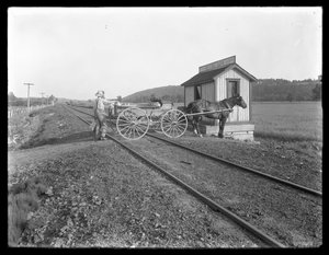 Unbekannter Mann lädt Milch auf einen pferdegezogenen Wagen, der über Eisenbahnschienen vor der McCready-Farm in Pennsylvania parkt, ca. 1913