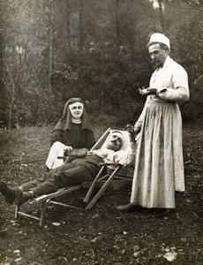 Arzt misst den Puls eines verletzten Mannes, assistiert von einer Krankenschwester-Nonne, ca. 1900 von . .