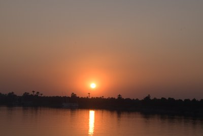 Goldene Sonnenuntergangsreflexionen auf einem ruhigen Fluss von Albert Mansour