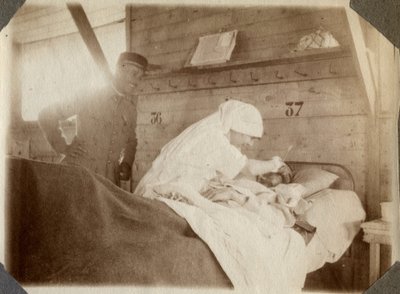 Erster Weltkrieg 1914-1918: Krankenschwester in einer Bluse rasiert einen Soldaten (französische Kriegswunden liegen im Bett), in Couville, Manche, Niedernormandie, Frankreich. Anonyme Fotografie Juli 1917. Private Sammlung, Stella. von Anonymous Anonymous