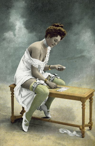 Mädchen mit entblößten Strümpfen und Brust spielt Geduld auf einem Holzschemel von French Photographer
