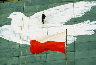 Ein Arbeiter bringt die letzten Details an einem großen Banner einer Friedenstaube an. Palast der C... von James L Stanfield