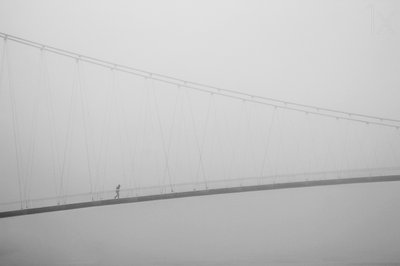Einsamer Spaziergang auf nebliger Brücke von Krunoslav Nevistic