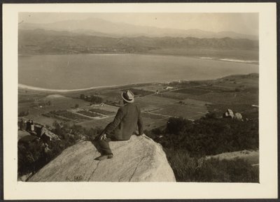 [Mann auf Felsvorsprung mit Blick auf Ackerland] von Louis Fleckenstein