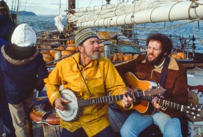 Musiker und Umweltschützer Peter Seeger spielt Banjo auf dem Deck der Clearwater im Hudson River von Ted Spiegel