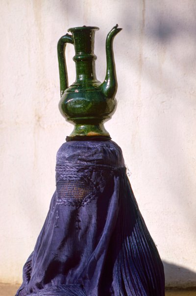 Frau in Kabul, abgeschirmt durch einen Seiden-Chadri alias Chador, trägt einen Krug von Thomas J. Abercrombie