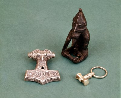 Amulette der Wikinger-Gottheiten: Im Vordergrund zwei kleine Silberhämmer, die den Gott Thor symbolisieren. Die Statuette stellt Freyr, den Fruchtbarkeitsgott, dar. Historisches Museum Stockholm, Schweden. von Viking Viking