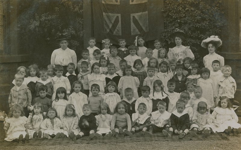 Schüler sitzen in einer Gruppe und posieren für ein Porträt von English Photographer