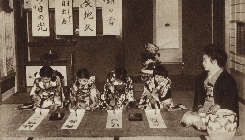 Japanische Schulmädchen schreiben mit Pinseln im Kindergartenunterricht von Photographer Japanese