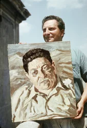 Der italienische Maler und Schriftsteller Carlo Levi (1902-1975) hält eines seiner Werke, ein Porträt des Gewerkschafters Giuseppe di Vittorio