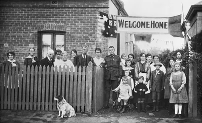 Gruppenporträt von 540 Sapper Arthur Findon Dunbar MM, 2nd Australian Tunnelling Company (in Uniform mit seinem Arm auf dem Tor ruhend) und seinen Familienmitgliedern vor ihrem Haus in der Chief Street 45