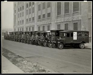 Eine Reihe von Lieferwagen, die vor der Carolyn Laundry in der 111 East 128th Street, East Harlem, New York, 1929, geparkt sind