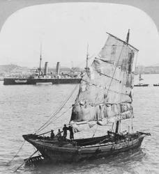 Chinesische Dschunke und britisches Kriegsschiff im Hafen von Hongkong, 1902