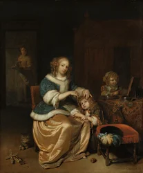 Innenraum mit einer Mutter, die ihrem Kind die Haare kämmt, bekannt als 