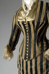 Abendkleid, ca. 1884 (teilweise seitliche schräge Ansicht). Seidensatin und geschnittener Samt, Spitze, Seidenfadenquasten und Fransen. Charles Frederick Worth, Frankreich.