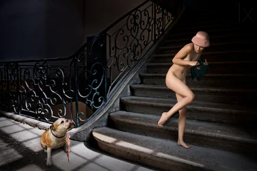 Nackte Frau auf dunkler Treppe