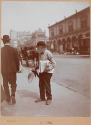 Ein Mann steht auf dem Bürgersteig der Broadway zwischen 34. und 35. Straße und hält die Zeitung The Evening Telegram