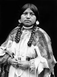 Cayuse-Frau, Halbporträt, stehend, frontal, Zöpfe, Muschelscheiben-Ohrringe, Muschelperlen-Halsband und Muschelperlen um den Hals, Perlen-Wildlederkleid mit Perlengürtel ca. 1910, Foto Edward S. Curtis