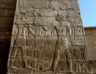 Ägyptische Antiquität: Totentempel von Ramses III. (1187-1156 v. Chr.). Flachrelief, das den Pharao darstellt, wie er die Insignien der Macht aus den Händen von Amon erhält. Luxor, Medinet Habu, Ägypten
