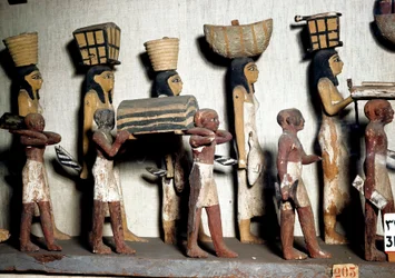 Ägyptische Antiquität: Eine geschnitzte Gruppe aus bemaltem Holz, die Diener darstellt, die dem Verstorbenen Opfergaben bringen. Kairo, Ägyptisches Museum