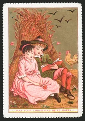 Junge liest Mädchen im Feld ein Buch vor