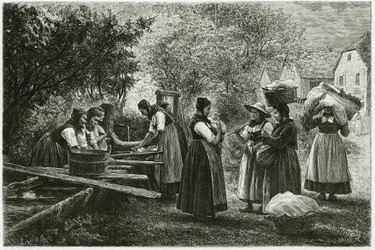 Eine Wäscherei in Metzeral, Frauen in traditionellen Taltrachten versammeln sich am Dorfbrunnen