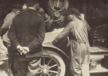 [Männer um die Motorhaube eines Autos gruppiert]
