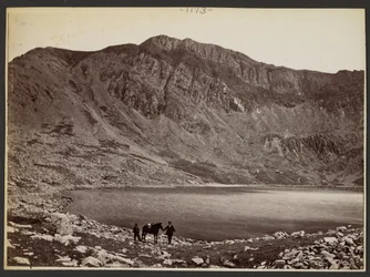 Männer und Pferd am See