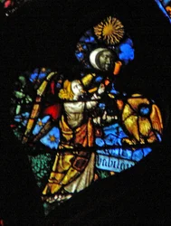 Das westliche Rosenfenster zeigt eine Szene aus dem Buch der Offenbarung: vierte Trompete Sonne, Mond und Sterne verdunkeln sich, und der Adler als Engel schreit Wehe, Wehe, darunter geschrieben (8:12-13).