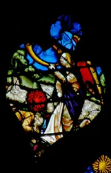 Das westliche Rosenfenster zeigt eine Szene aus dem Buch der Offenbarung: dritte Trompete; der Stern Wermut fällt auf die Gewässer (8:10-11).