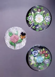 Drei Briefbeschwerer, LtoR: Clichy-Rose und Stiefmütterchen mit opakem weißem Latticinio-Grund, und zwei Baccarat-Sträuße mit sternförmig geschnittenen Basen