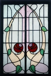 Ein Buntglasfenster, das stilisierte Rosen darstellt